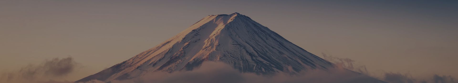 Pointe du Mont Fuji entourée de nuages avec un couché de soleil rose