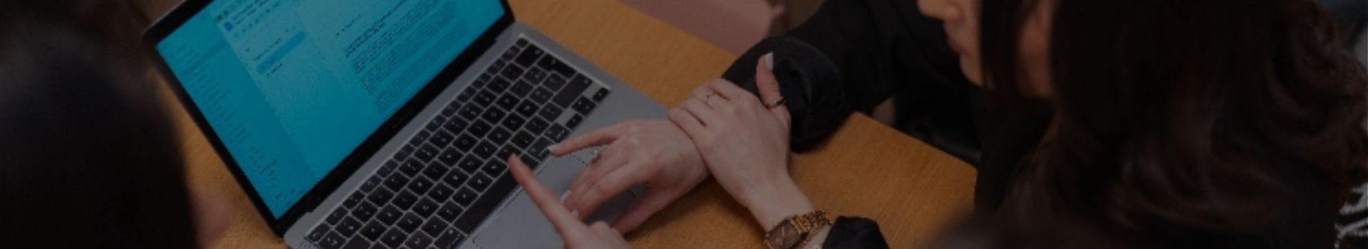 Mains d'étudiantes pointant un ordinateur portable