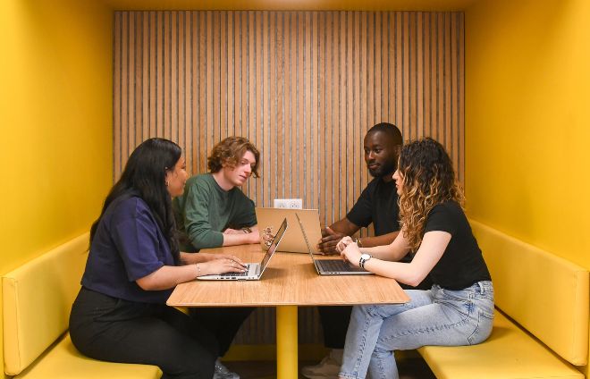Groupe de quatre étudiants qui travaillent ensembles