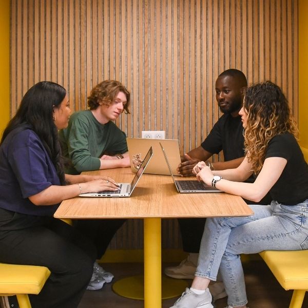 Etudiants de l'ESGCI Groupe de quatre étudiants assis autour d'une table face à leurs ordinateurs