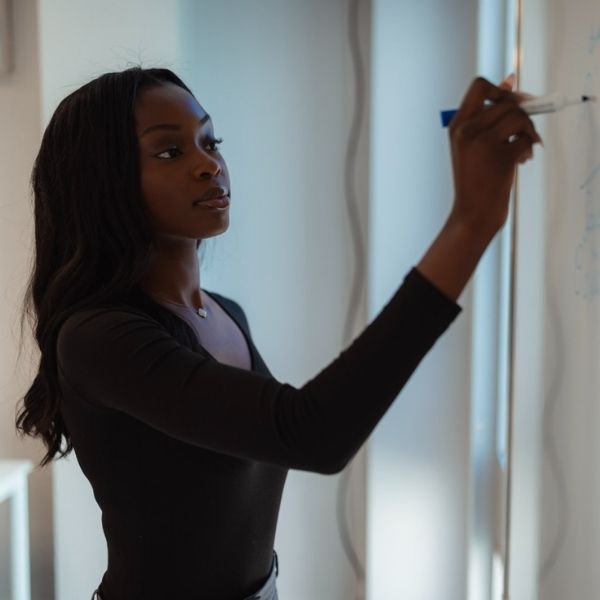 Profil étudiant : Lisa Kubieda, entre études et projets professionnels Etudiante en Mastère 2 International Business, de côté et écrivant sur un tableau