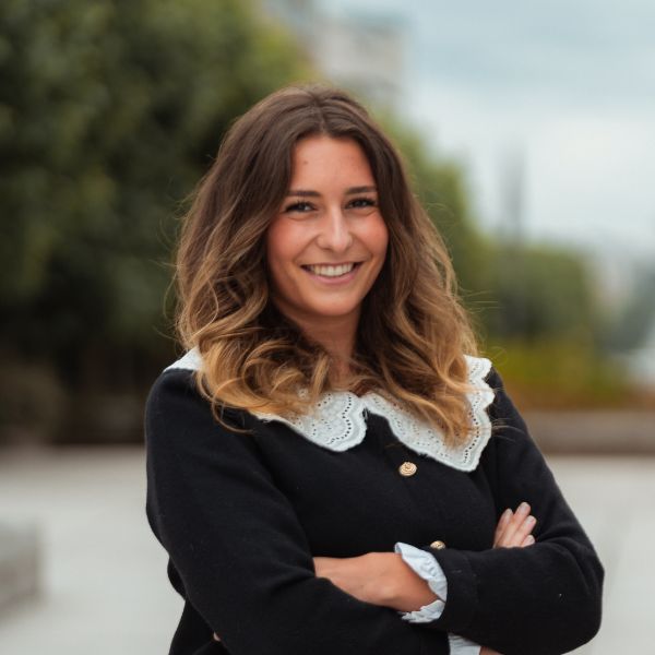 Etudiantes en Mastère Marketing Produit : Cosmétiques et Bien-être Etudiante souriant face caméra avec les bras croisés