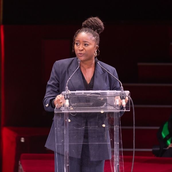 Anna MENDY, Responsable de la scolarité Femme en tenue professionnelle donne un discours dans une salle de spectacle