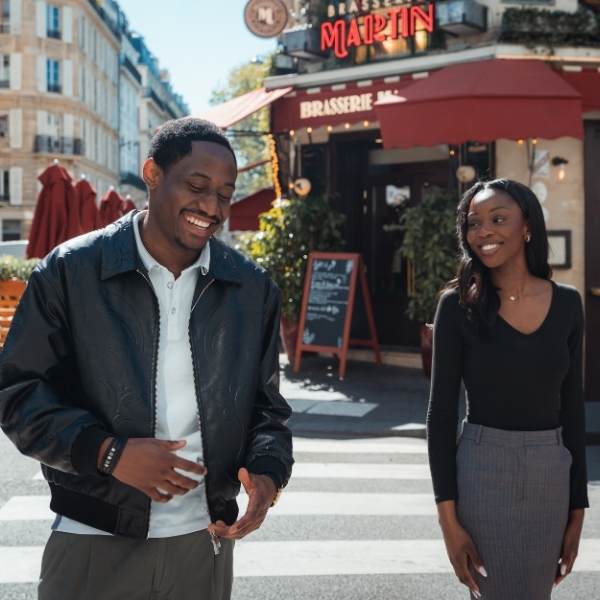 Un jeune homme et une jeune femme devant un restaurant parisien