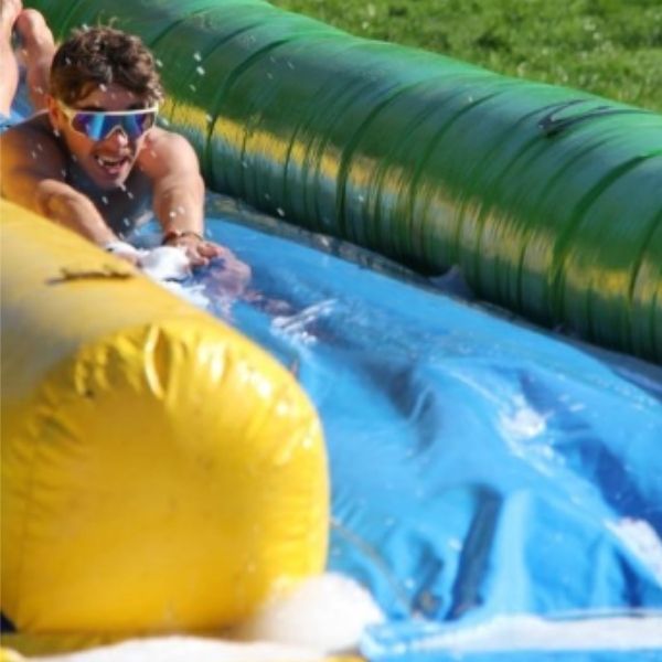 Etudiant de l'ESGCI au week-end d'intégration Etudiant de l'ESGCI glissant sur le ventre face caméra sur un toboggan moussant
