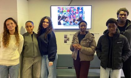 Six étudiants debout et face caméra en premier plan et derrière eux un écran avec une photo de manga